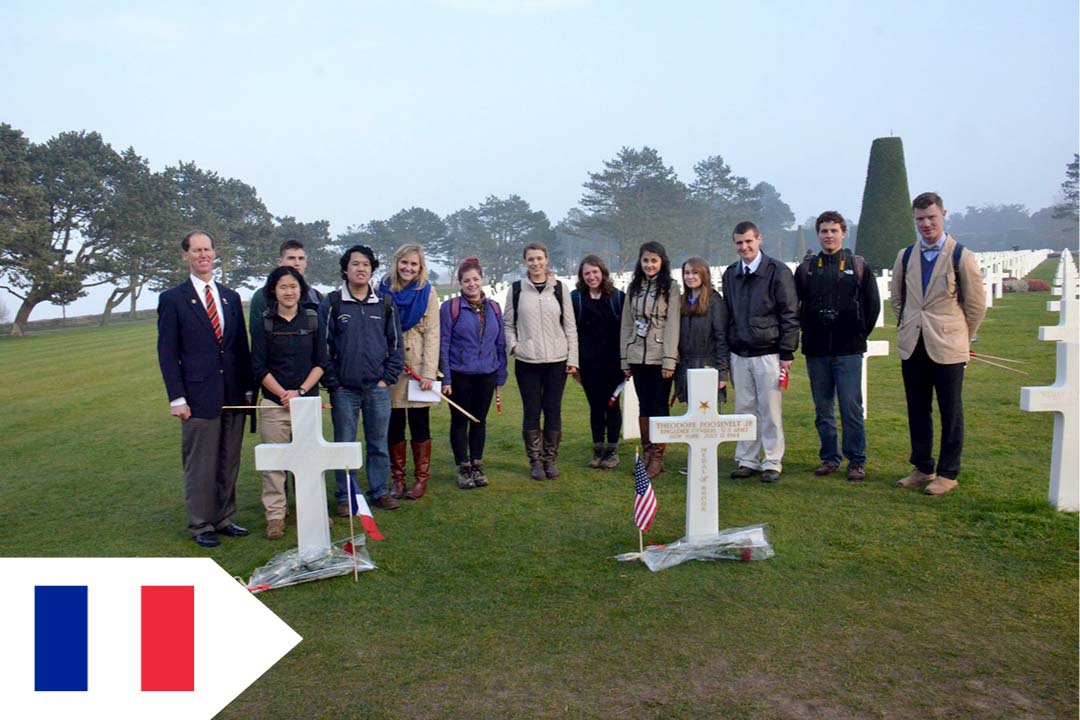 GW students in front of a white cross in Normandy