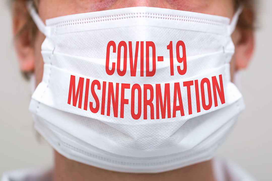 COVID-19 Misinformation in red text on a white mask