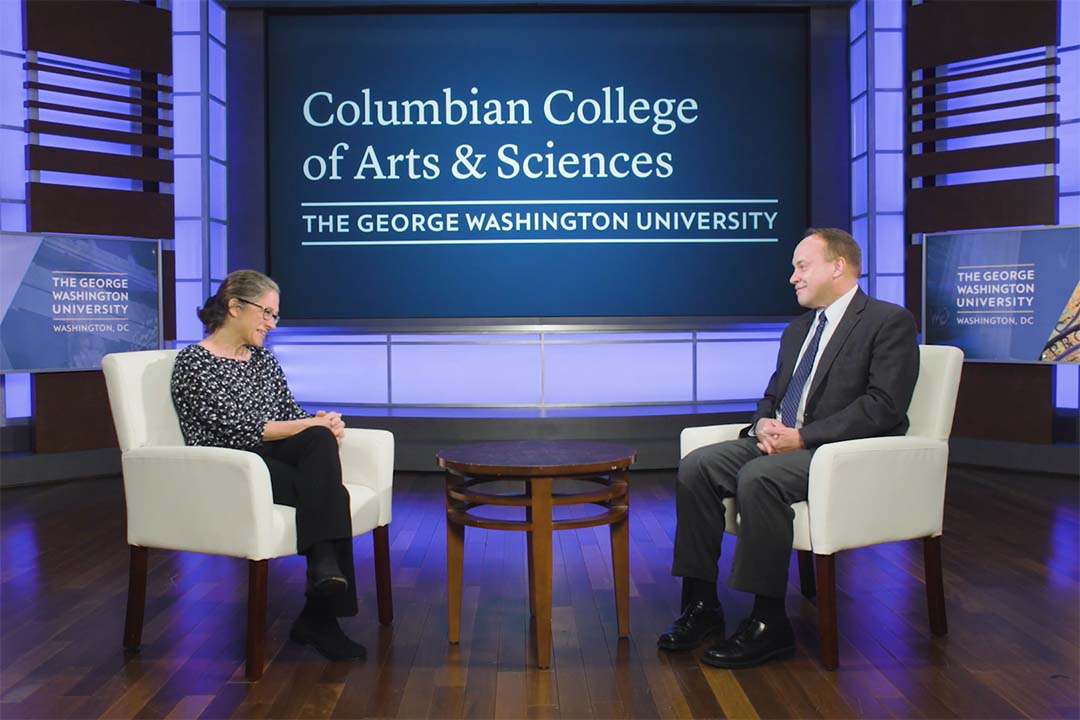 Sarah Binder and Paul Wahlbeck seated onstage talking in front of a Columbian College sign