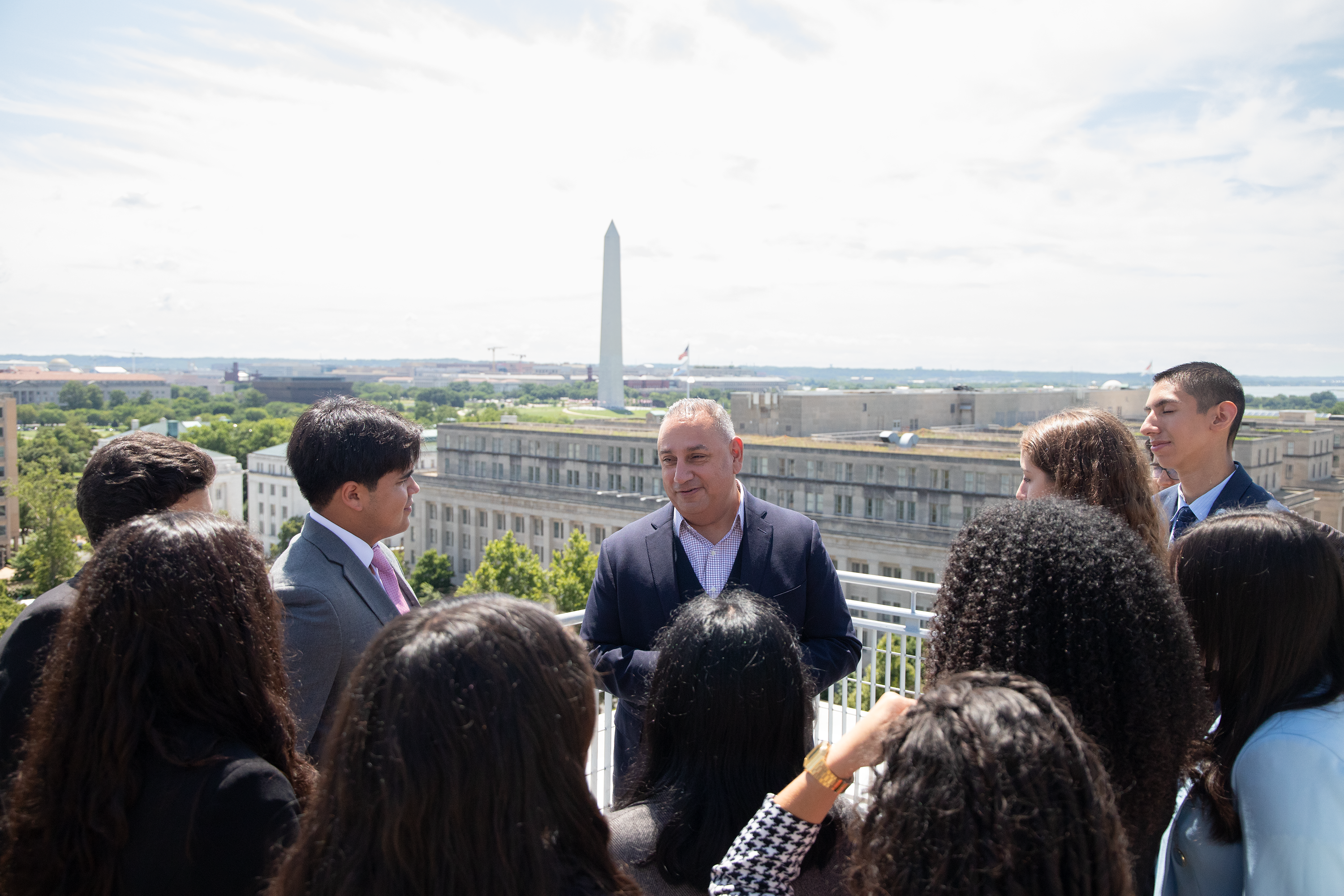 Gilbert Cisneros, BA ’94, spoke with students from the Caminos al Futuro on the terrace of the City View Room overlooking the Washington Monument.