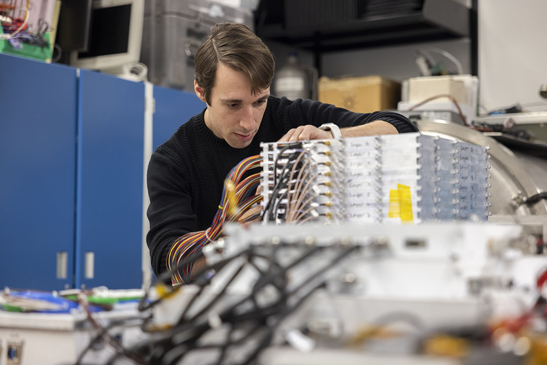 Physics Ph.D. student Nick Kirschner working with wires in a physics lab