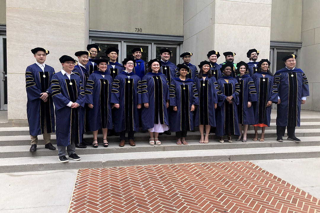 Master's students at the CCAS 2024 celebration in caps and gowns standing together