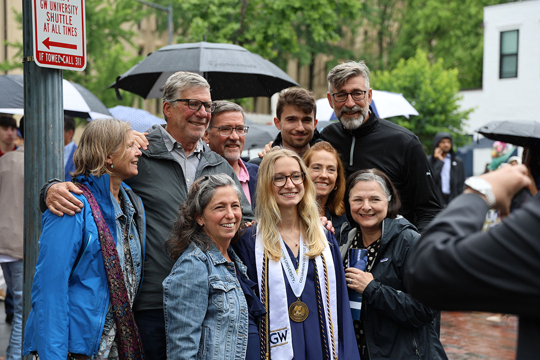 A family smiling around their newly graduated family member at the 2024 CCAS Undergraduate noon celebration