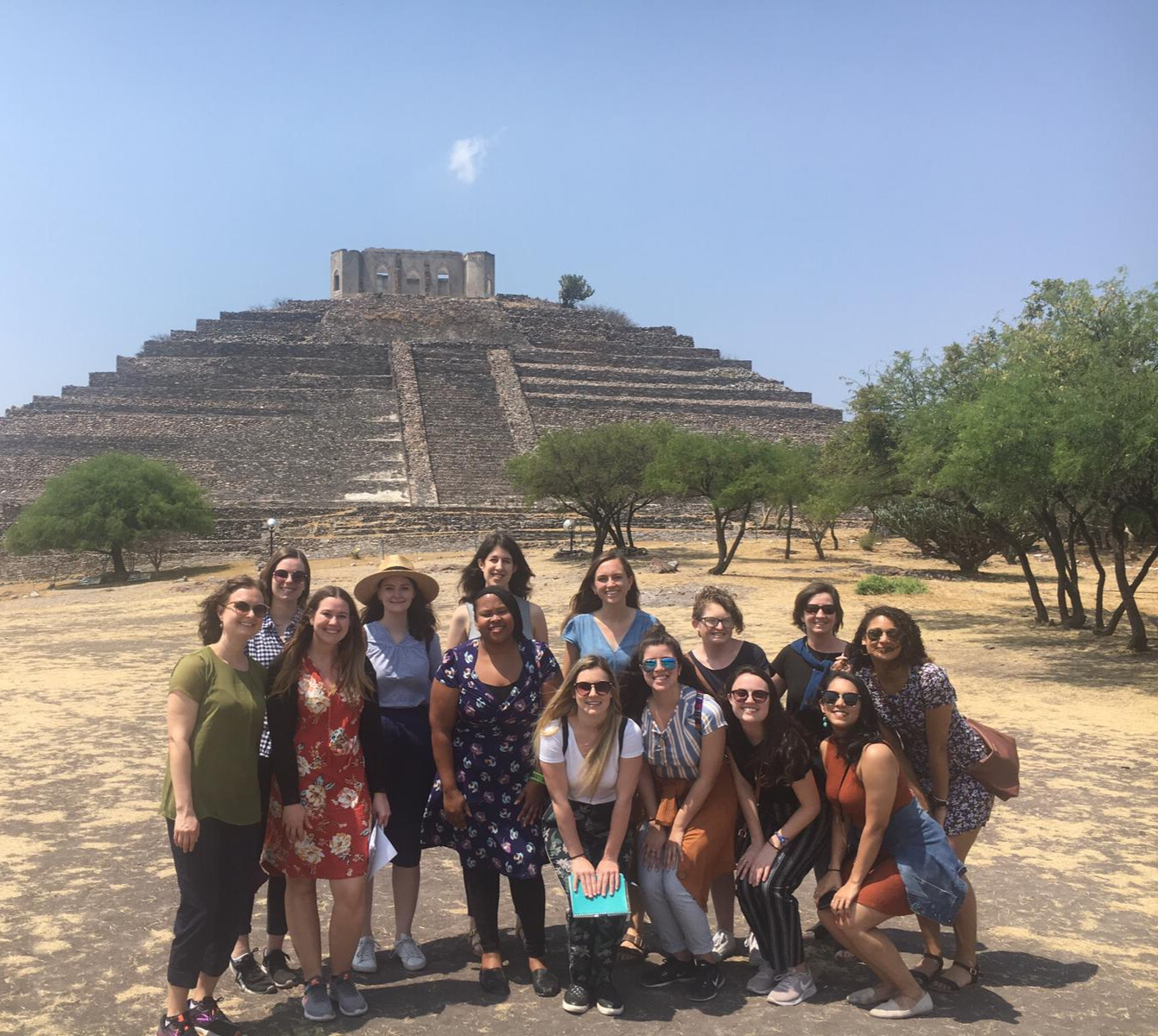 Students posing for a group photo in front of a pyramid in Mexico.