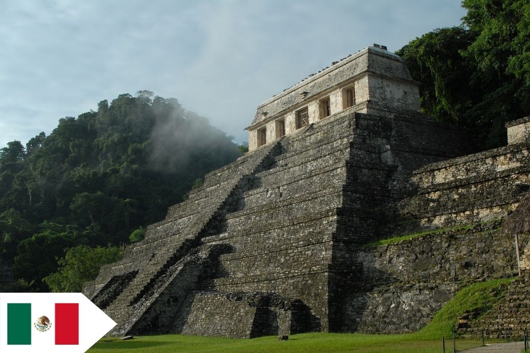 A Mayan pyramid is framed off-center with a misty jungle in the background