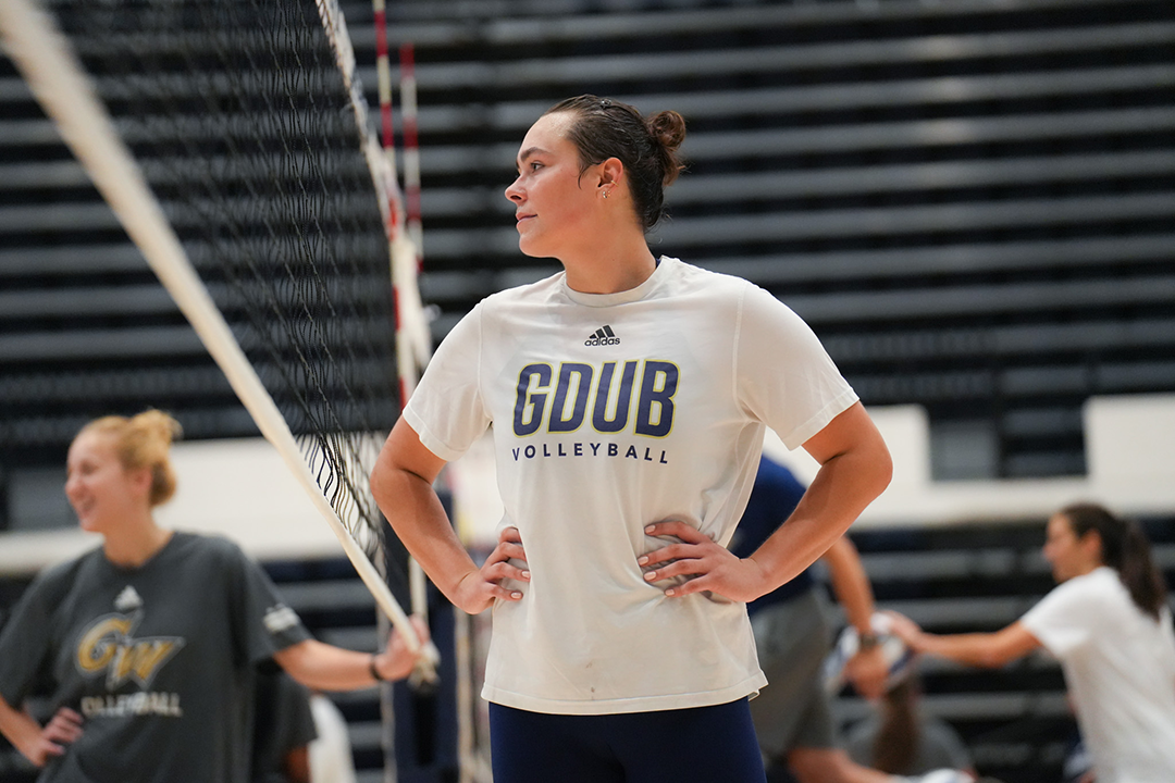 MC Daubendiek standing in a GDUB tshirt on the volleyball court