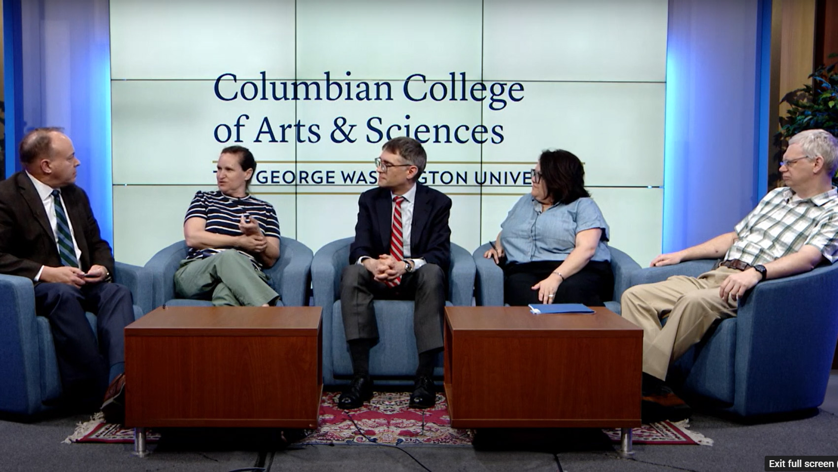 Paul Wahlbeck seated on a Columbian College stage with four CCAS professors in a panel