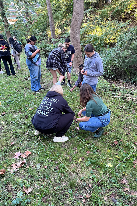Graduate students in Eldridge’s Crime Scene Investigations I class practice a crime scene mapping technique to measure the location of found evidence at an outdoor scene.