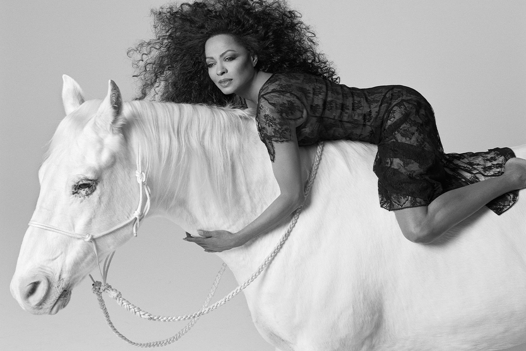 Diana Ross sitting on top of a white horse