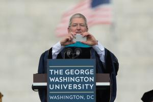Apple CEO Tim Cook takes a photo at the George Washington University 2015 Commencement Ceremony