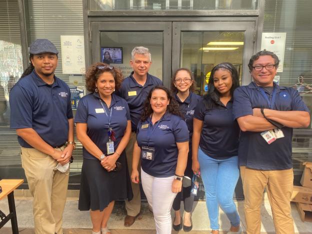 Seven members of the Student Services Team standing together in front of Smith Hall 118