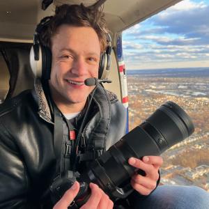 Ryan Patterson in a helicopter with a camera