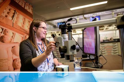 Cassie Green working with a microscope and computer on a museum collection