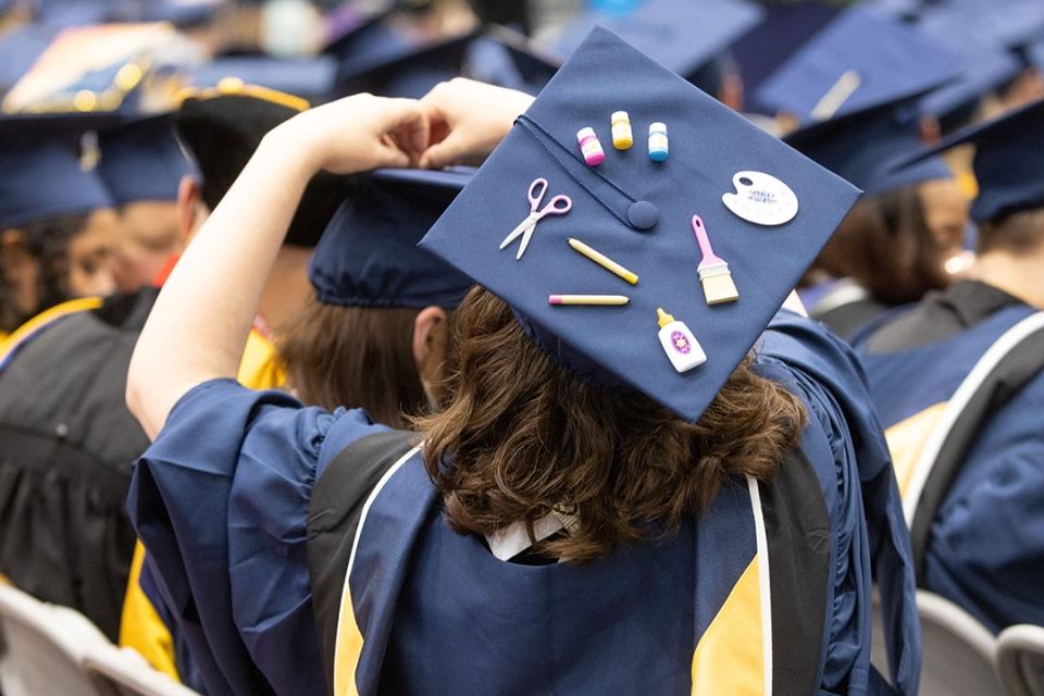 Grad cap embellished with scissors, glue, paintbrushes and pencils
