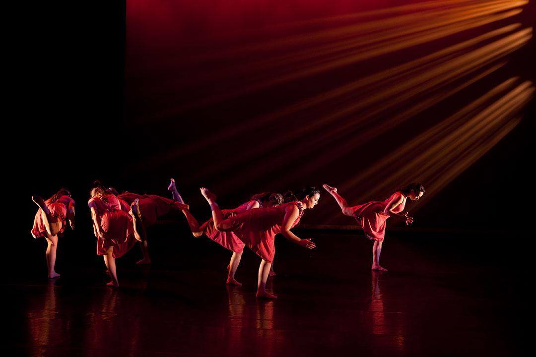 Corcoran dancers in red performing on a stage