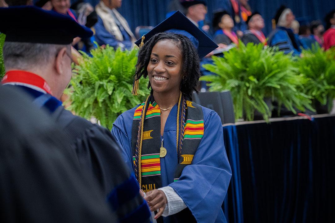 A CCAS undergraduate student in graduation cap and gown