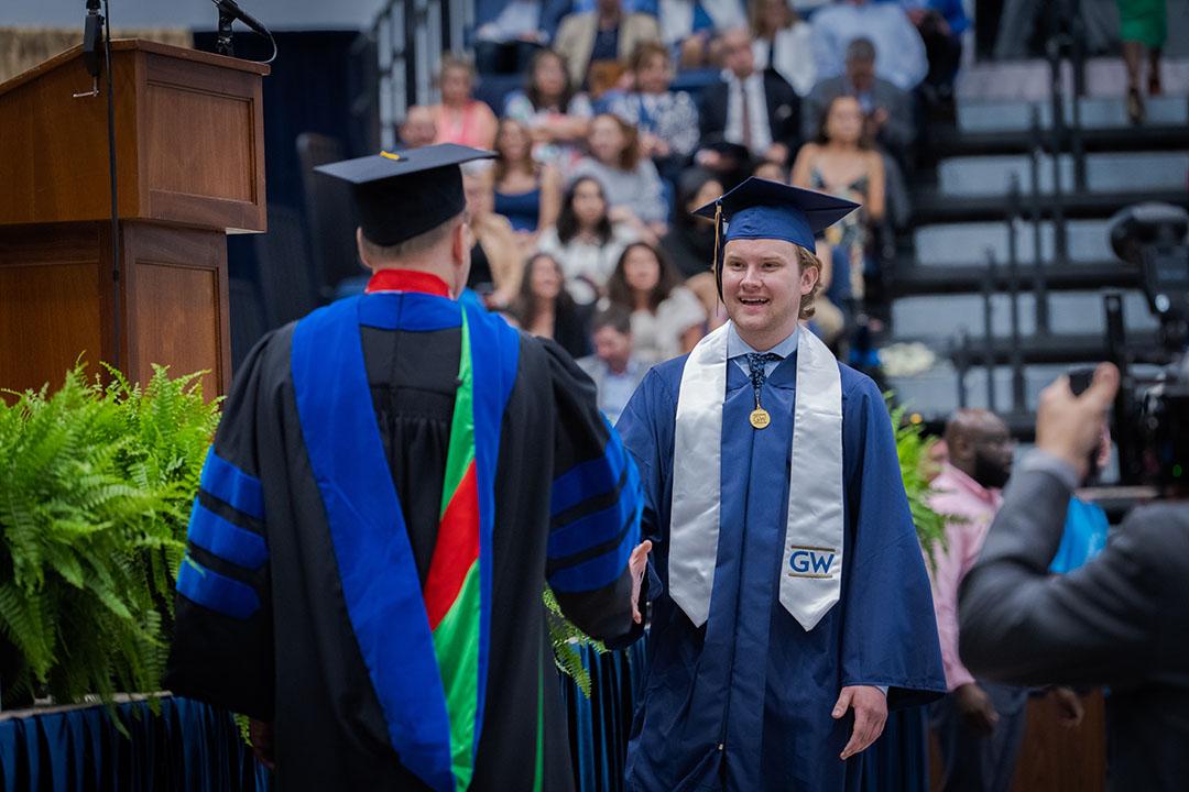 A CCAS undergraduate student in graduation cap and gown