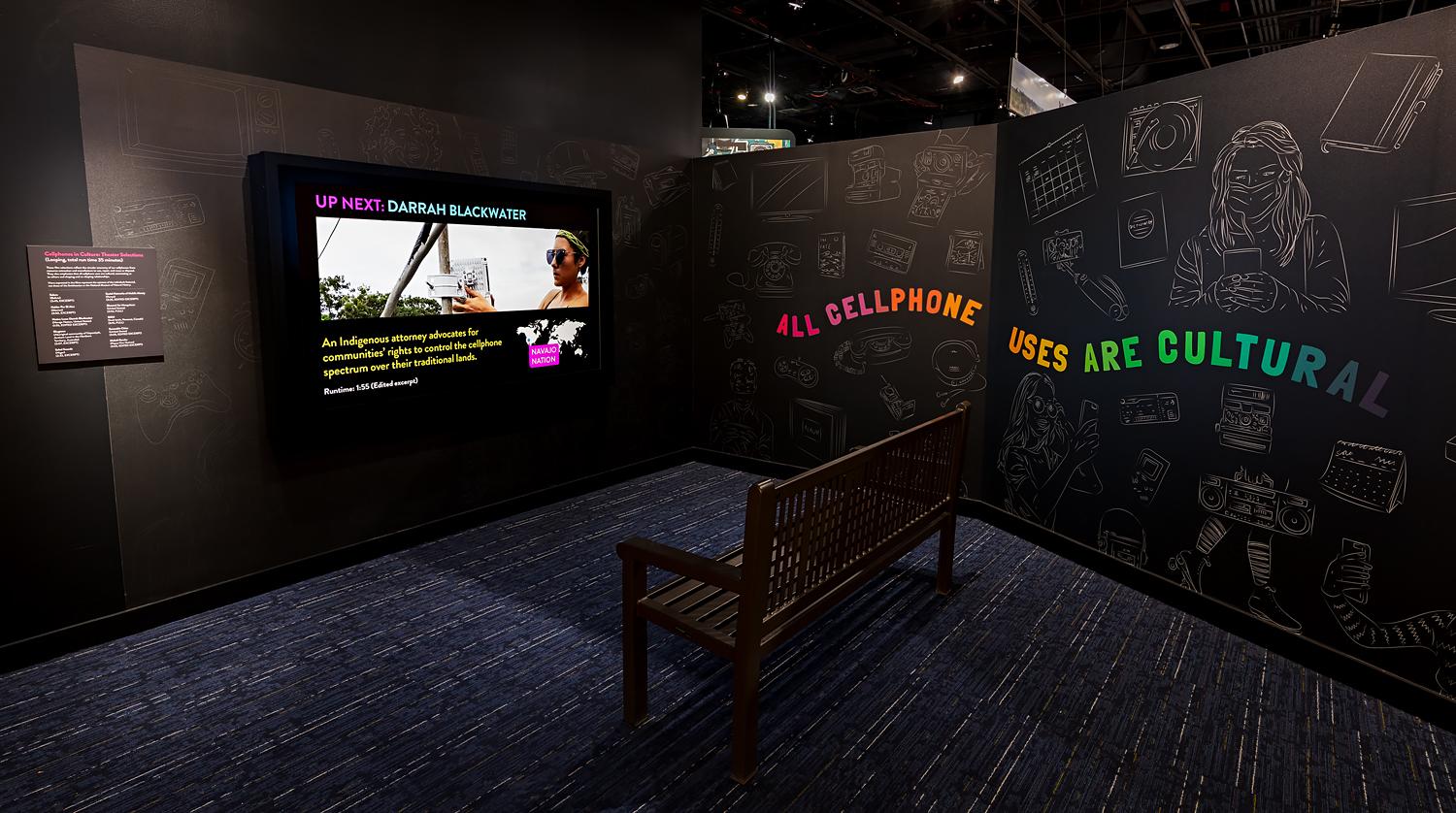 projected video against an exhibit wall about cell phones