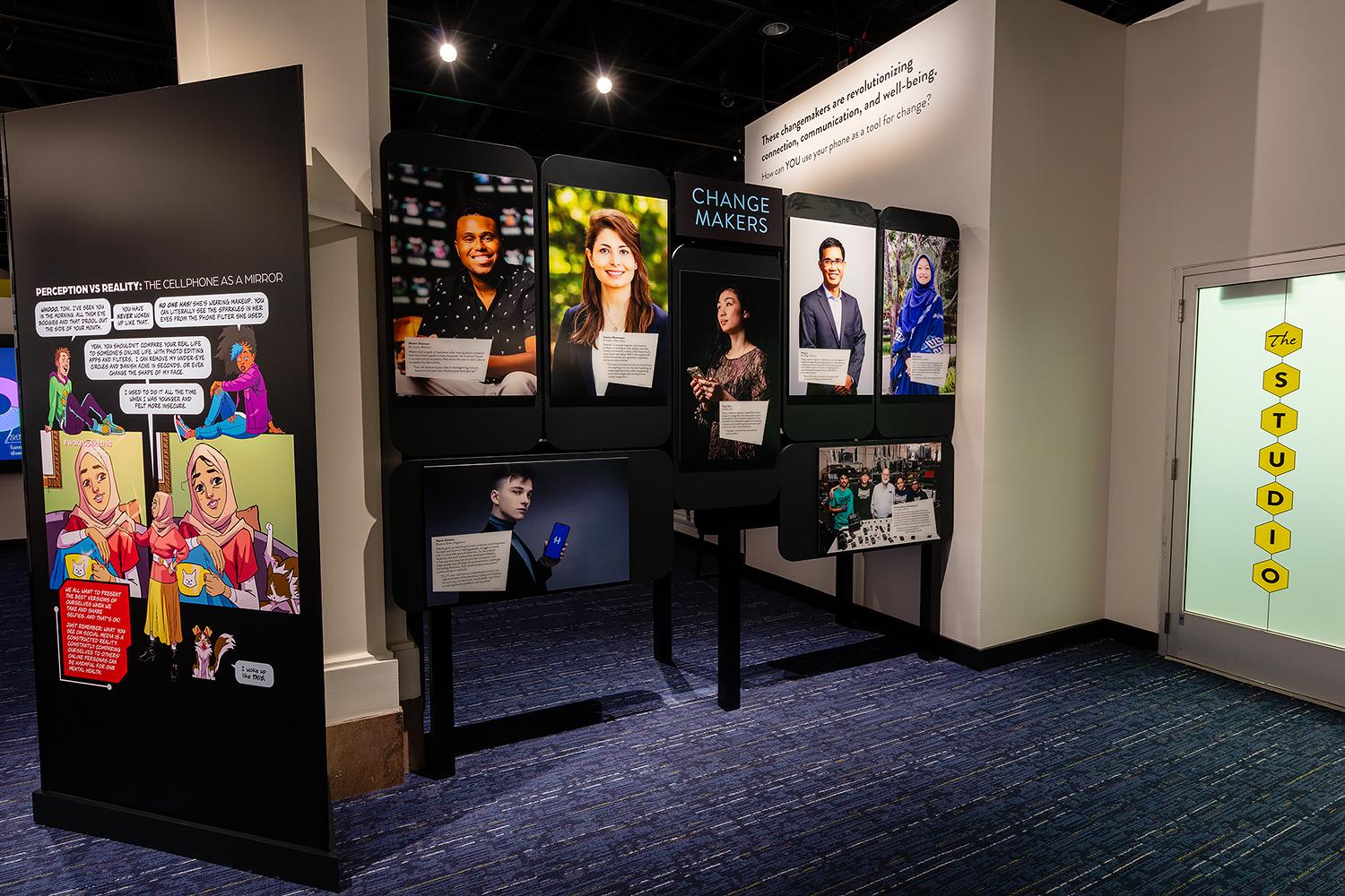 comic strips and headshots of people at an exhibit about cell phones