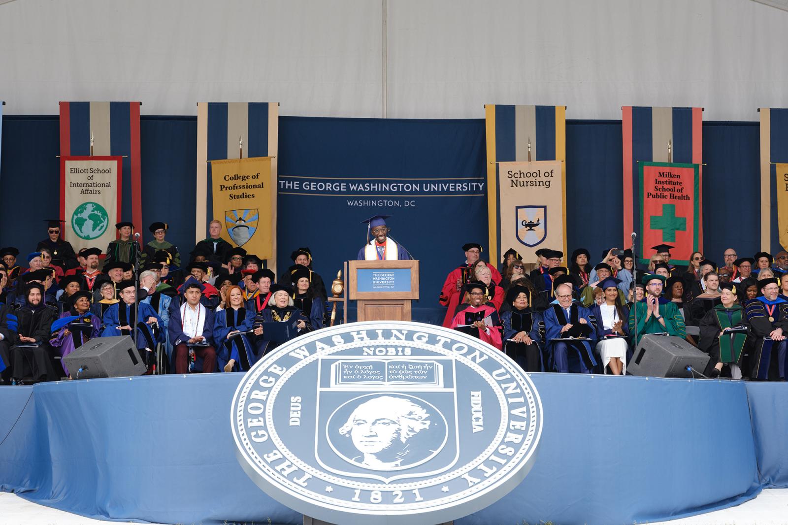 student speaker addressing the crowd from a podium at the 2024 GW Commencement ceremony