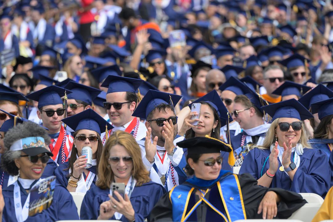 GW students in graduation caps and gowns on the National Mall