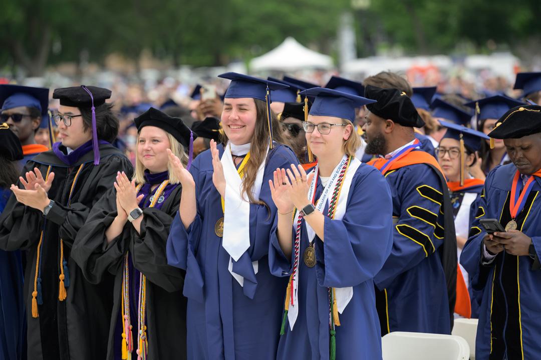 GW students in graduation caps and gowns on the National Mall