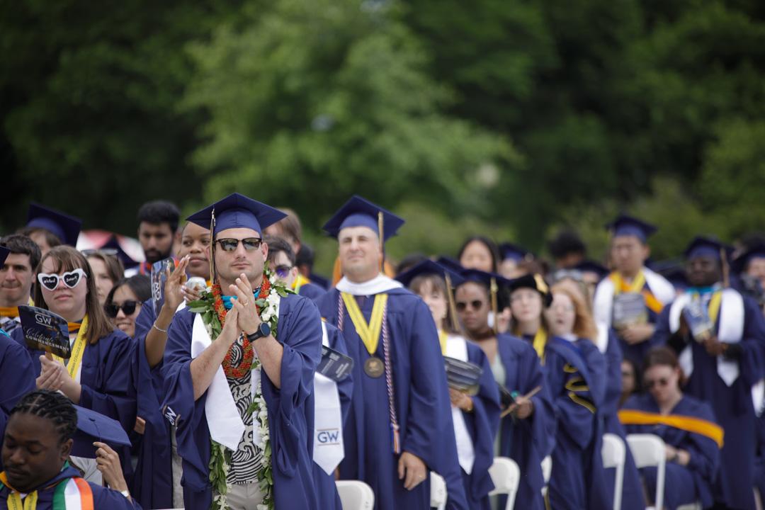 GW students in graduation caps and gowns on the National Mall