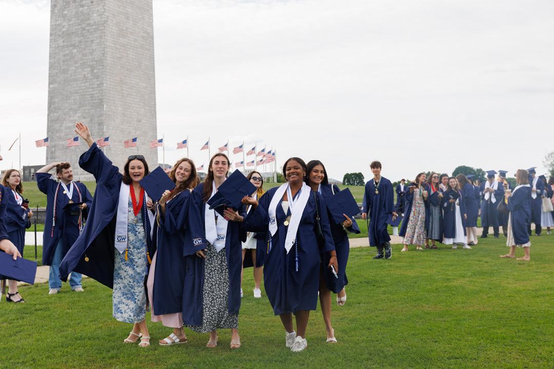 GW students in graduation caps and gowns on the National Mall