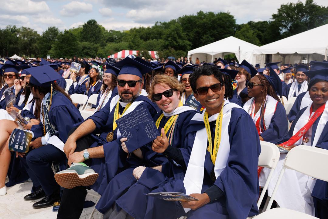 GW students in graduation caps and gowns on the National Mall