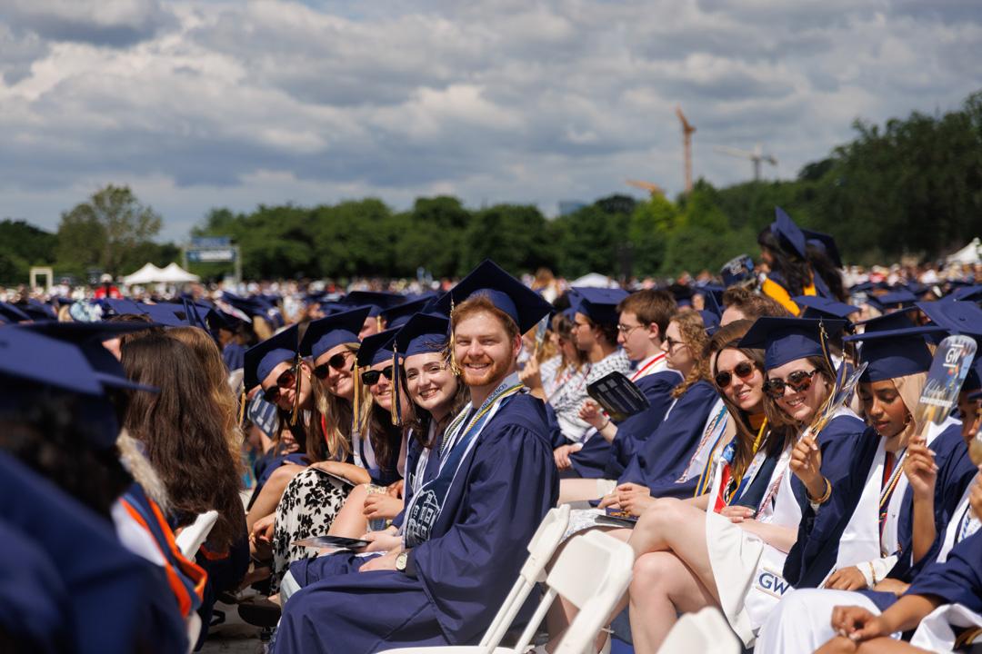 GW students in graduation caps and gowns on the National Mall