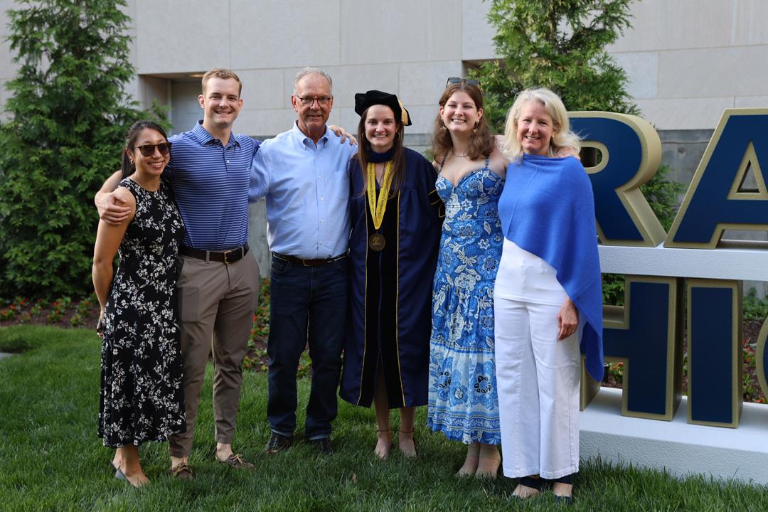 A CCAS doctoral graduate standing outside with her family and friends