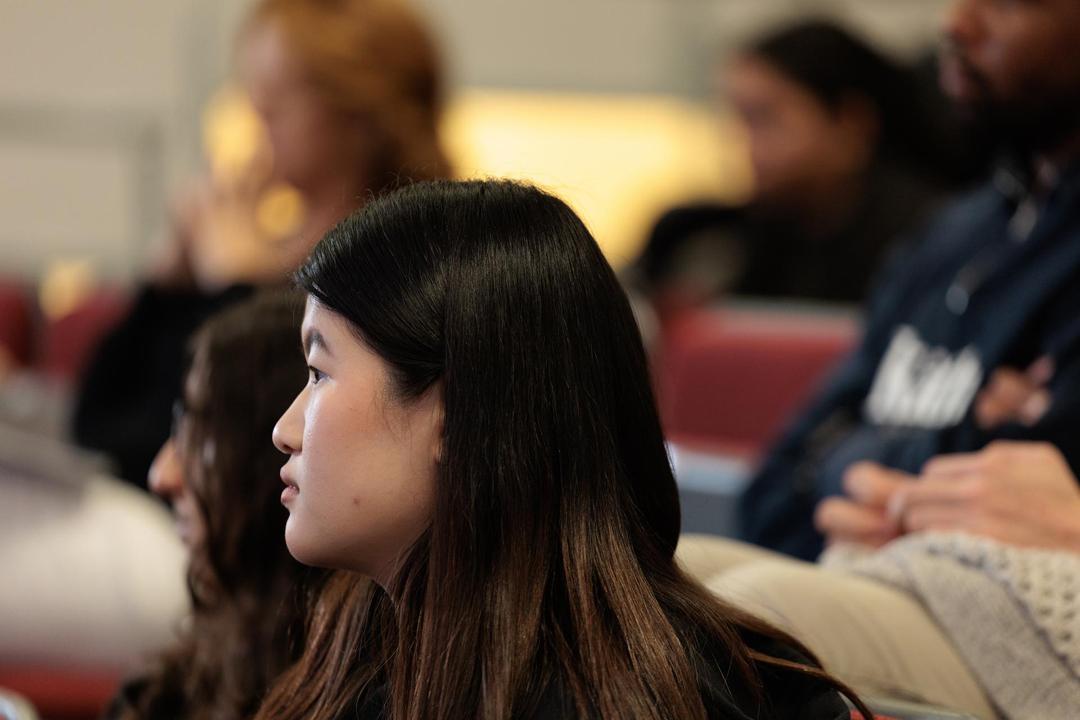 An audience member in profile listening