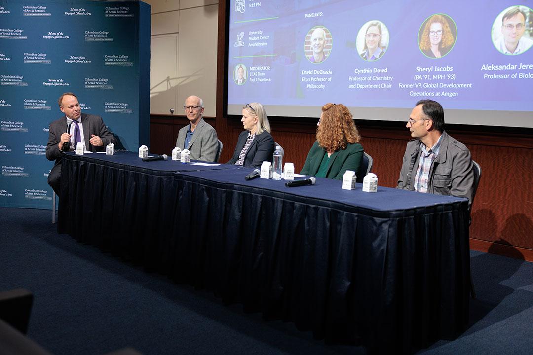 Dean Paul Wahlbeck and four experts and alumni seated at a table speaking to an audience