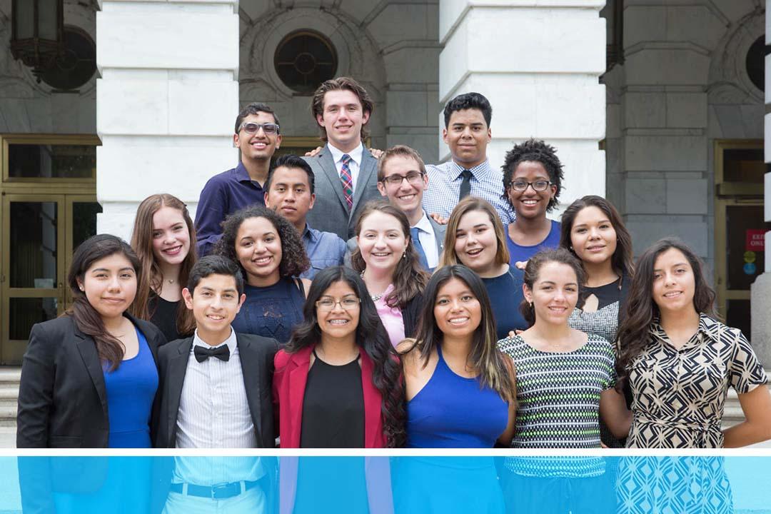A large group of students smiling in front of an official DC building