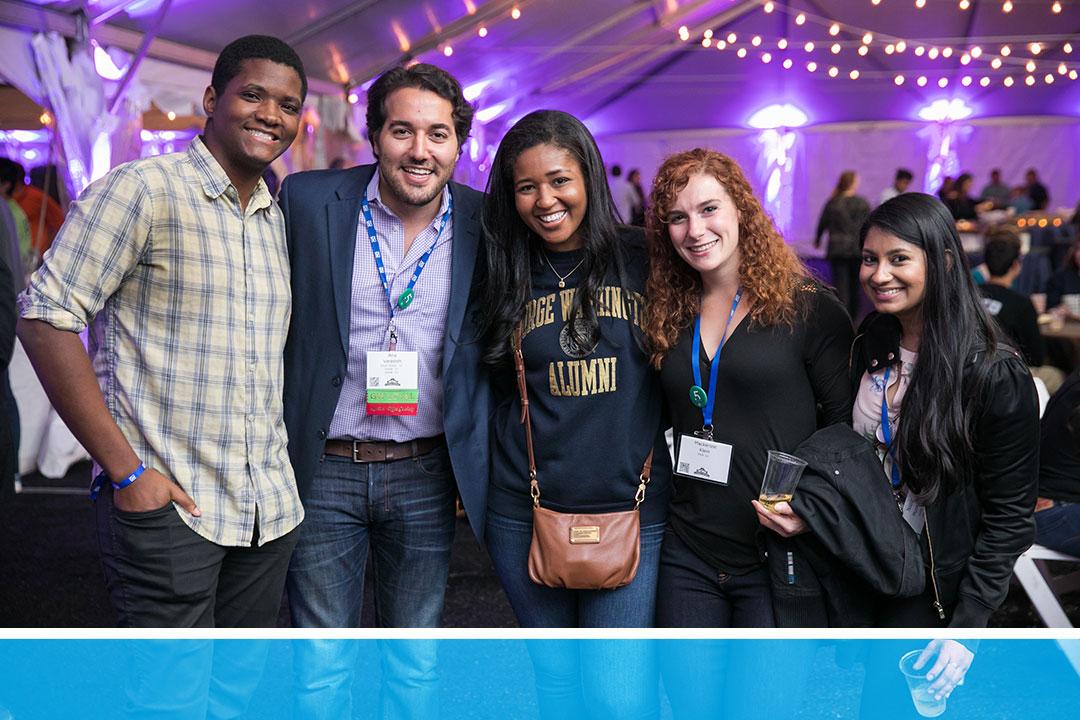 Group of alumni smiling in a crowded party