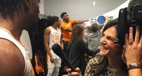 Danielle Santoro interviewing basketball player in a locker room.