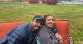 Mohammed and his sister embrace on a couch outdoors