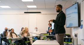 Michael Kidd-Gilchrist stands in front of a classroom while he speaks to students